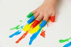child with finger paints colors